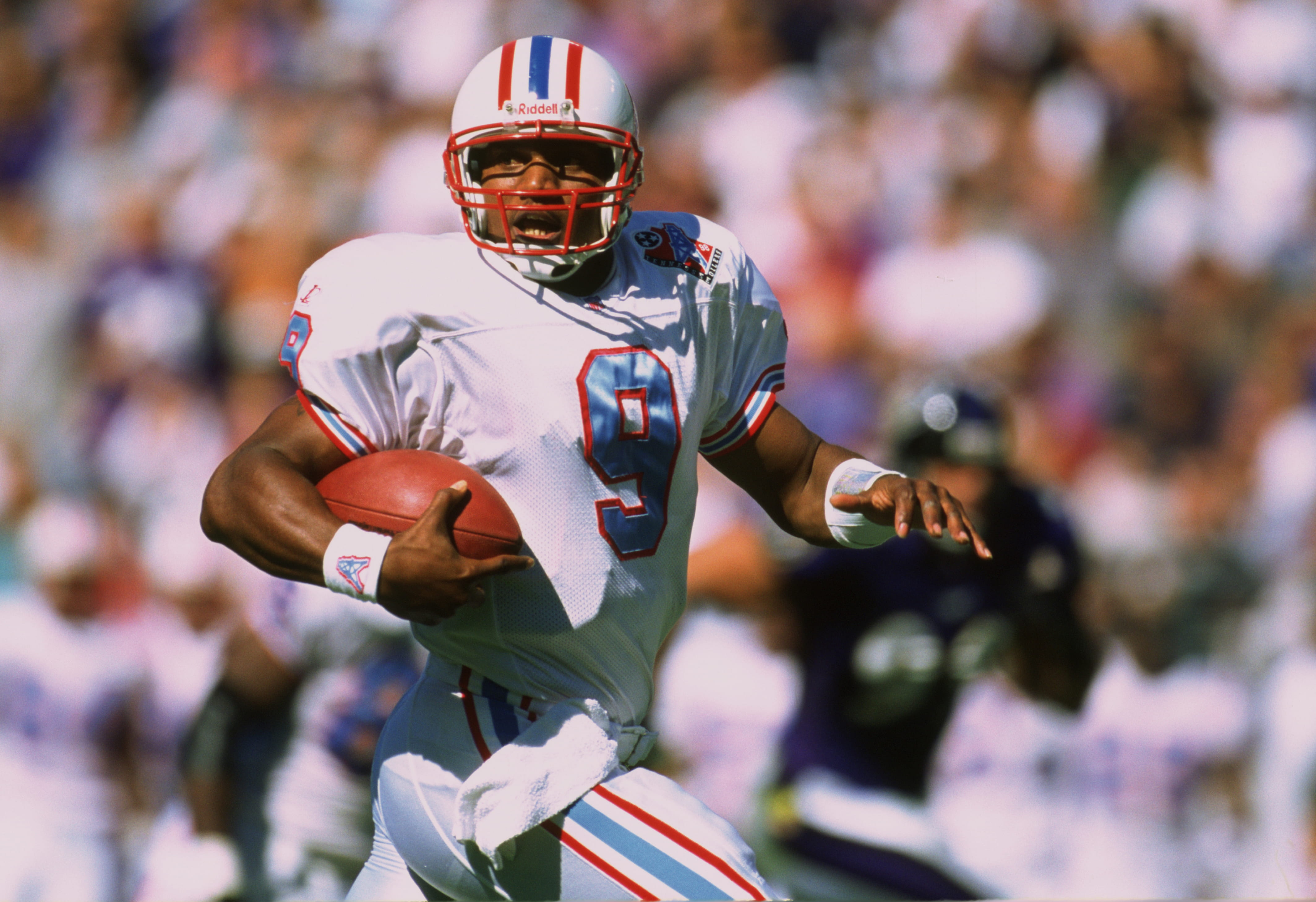 Tennessee Oilers quarterback Steve McNair carries the ball during a game in 1998.
