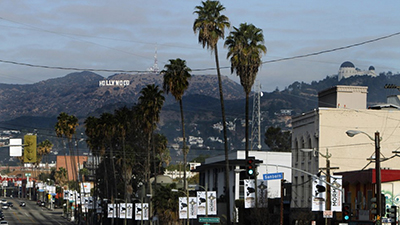 The Hollywood Sign and Griffith Observatory overlook a crowded Silver Lake street. (Francine Orr / Los Angeles Times)
