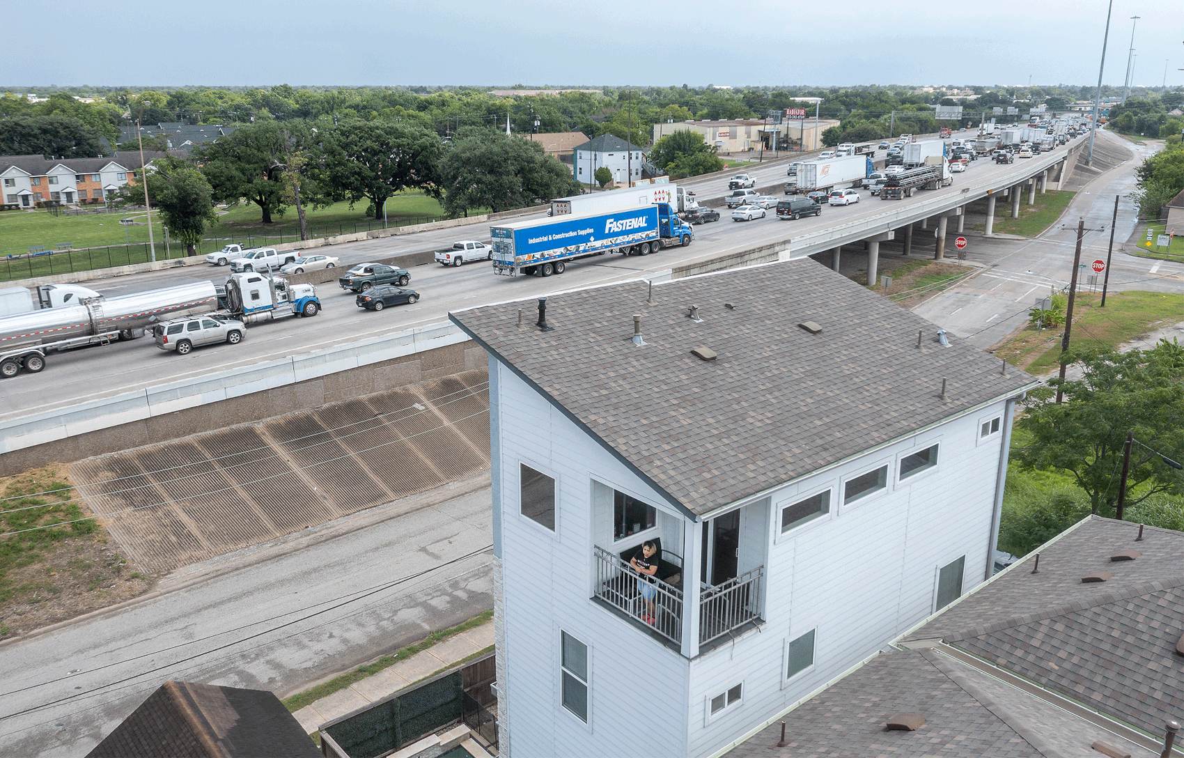 Modesti Cooper, de 35 años, mira desde el balcón del cuarto piso de su casa, junto a la Interestatal 10, cerca del centro de Houston.